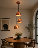 Hudson modern copper three shade cluster pendant light installed above a contemporary dining table in a modern dining room