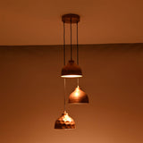 Hudson modern copper three shade cluster pendant light creating warm downward illumination in a dark setting
