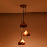 Warm illuminated view of Hudson modern copper three shade cluster pendant light with artisan copper dome shades