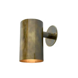 Angled view of the Hudson modern brass cylinder wall sconce showcasing the cylindrical shade and wall mounting arm.