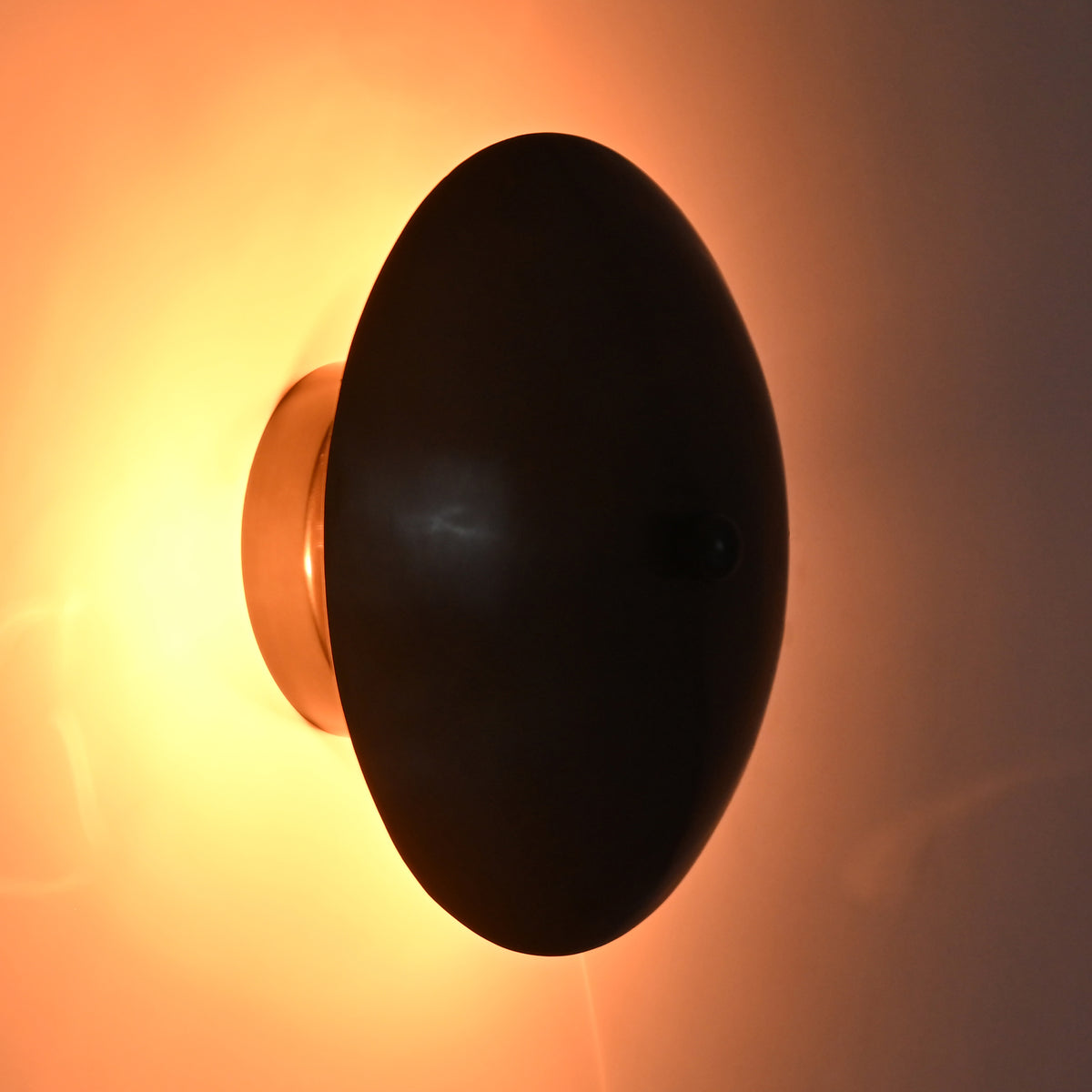 Close-up of the Hudson Modern Dome Wall Sconce emitting a warm ambient glow with concealed lighting behind the dome shade.