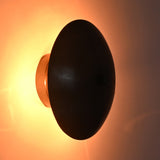 Close-up of the Hudson Modern Dome Wall Sconce emitting a warm ambient glow with concealed lighting behind the dome shade.