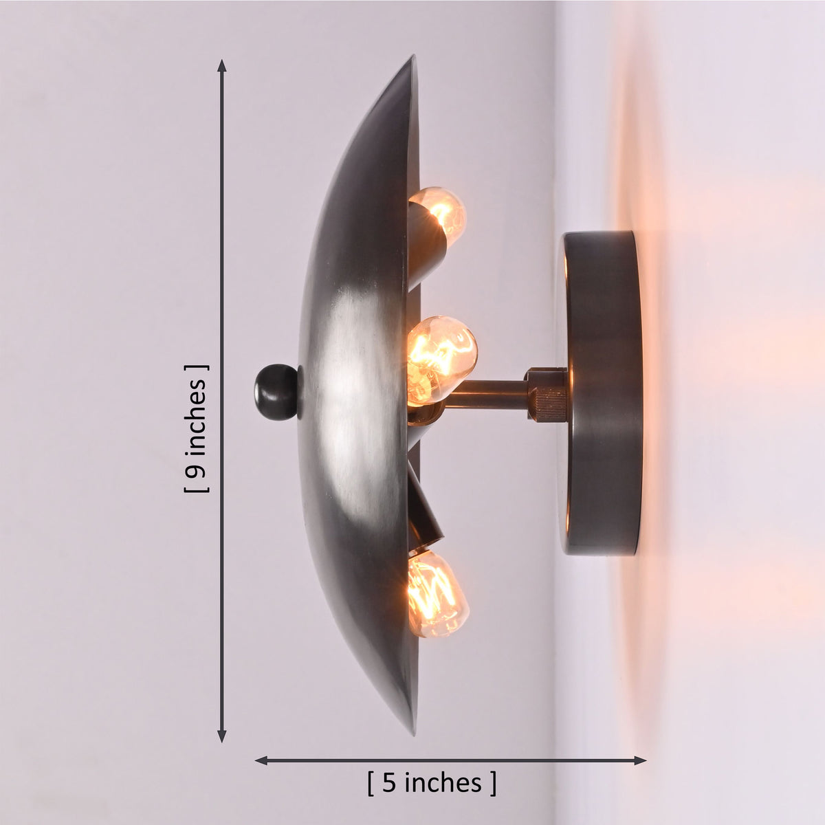 Side profile of the Hudson Modern Dome Wall Sconce displaying its 9-inch height and 5-inch depth with three concealed light bulbs.