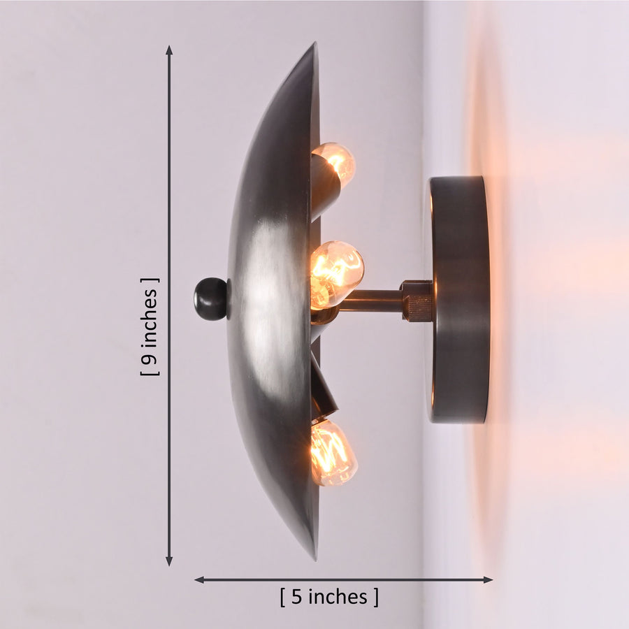 Hudson Modern Dome Wall Sconce installed in a contemporary living room, casting a warm ambient halo against the wall.
