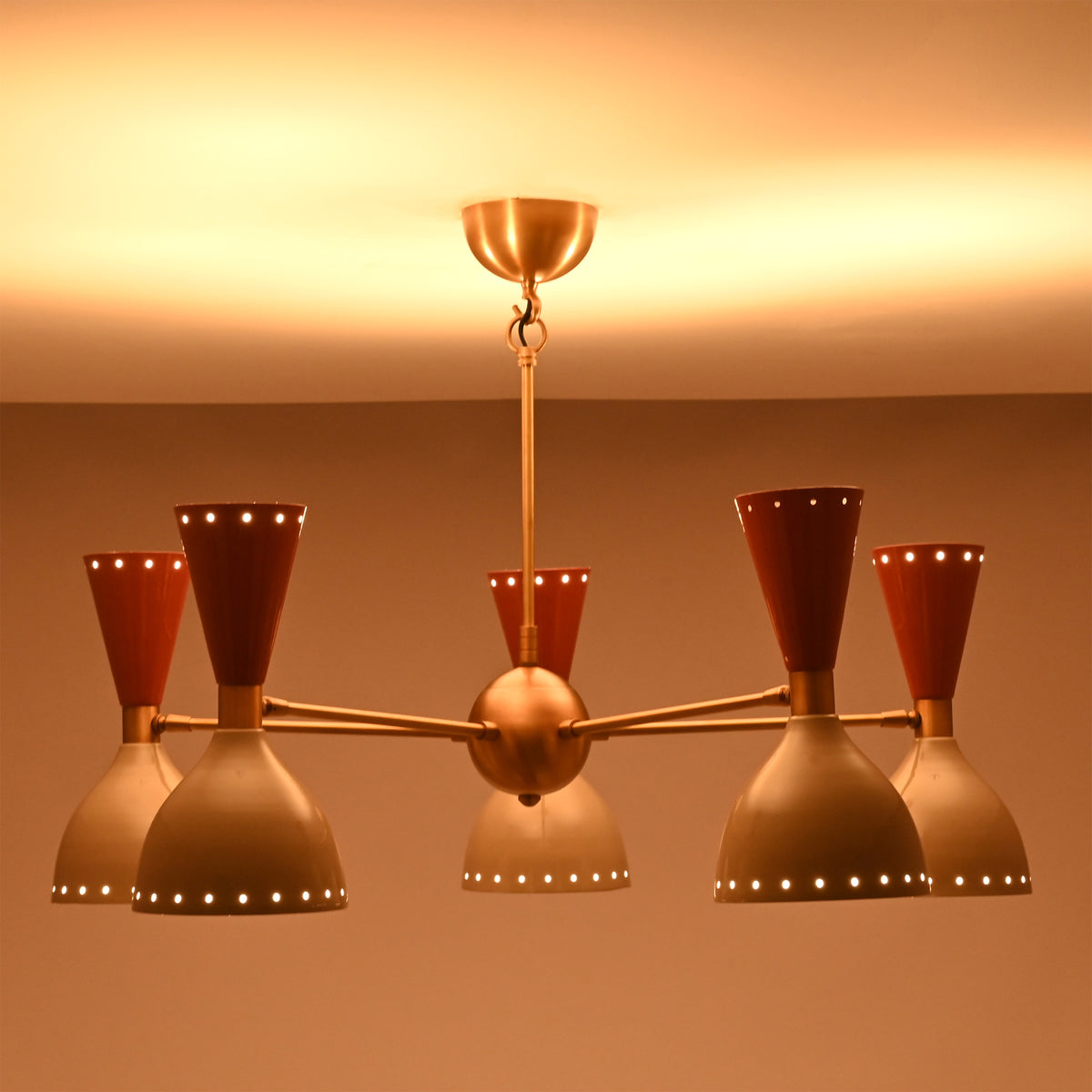 Side view of illuminated Hudson Modern five-light chandelier with perforated cone shades creating decorative ambient ceiling lighting.