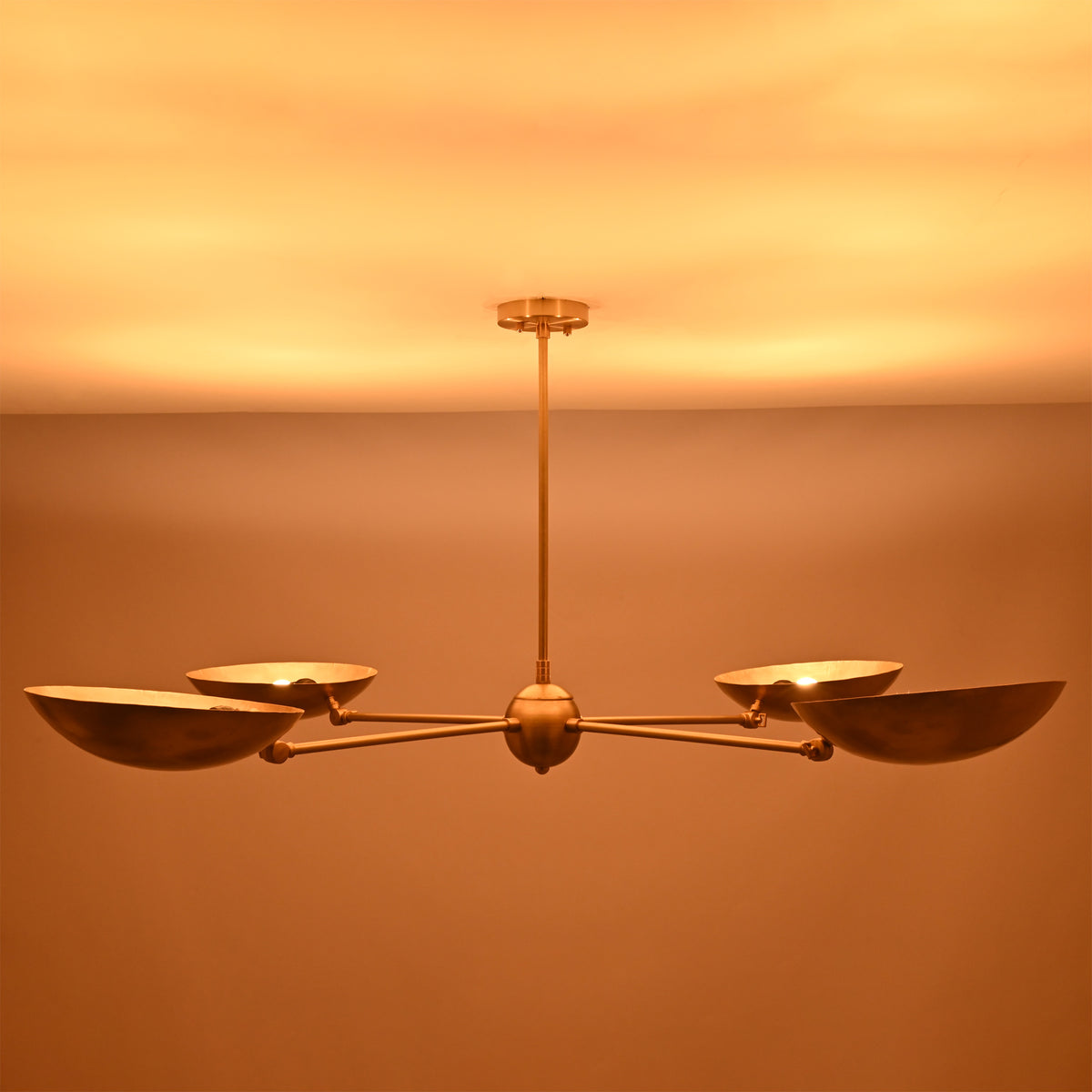 Interior illuminated view of the Hudson Modern Quad Bowl Chandelier showing concealed light sources within the handcrafted metal bowl shades.