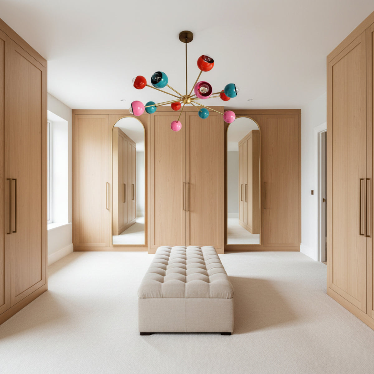 Hudson 12 light multicolor Sputnik chandelier shown from an angled view with pink, turquoise, and red rounded shades and brass-tone radial arms.