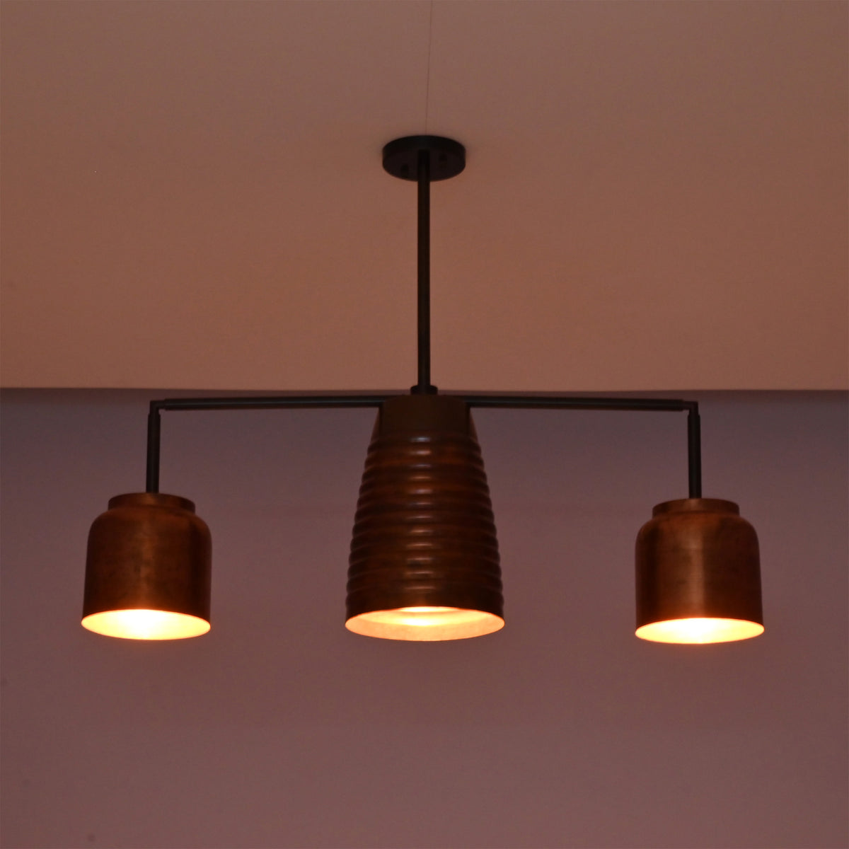 Front night view of the Hudson Modern Linear Three Shade Chandelier showcasing balanced warm lighting and a sculptural linear silhouette.