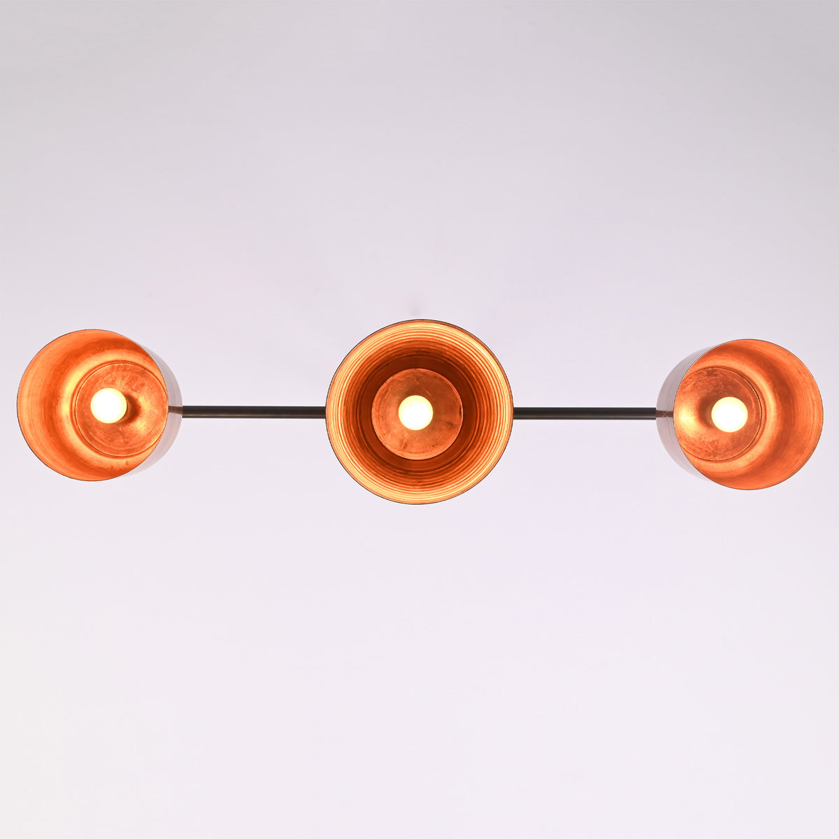 Bottom view of the Hudson Modern Linear Three Shade Chandelier displaying the illuminated interiors of the three handcrafted metal shades.