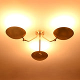 Bottom illuminated view of Hudson brass triple dish chandelier demonstrating soft upward light distribution.