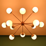 Bottom view of an illuminated brass Sputnik chandelier with frosted globe shades casting warm ambient light.