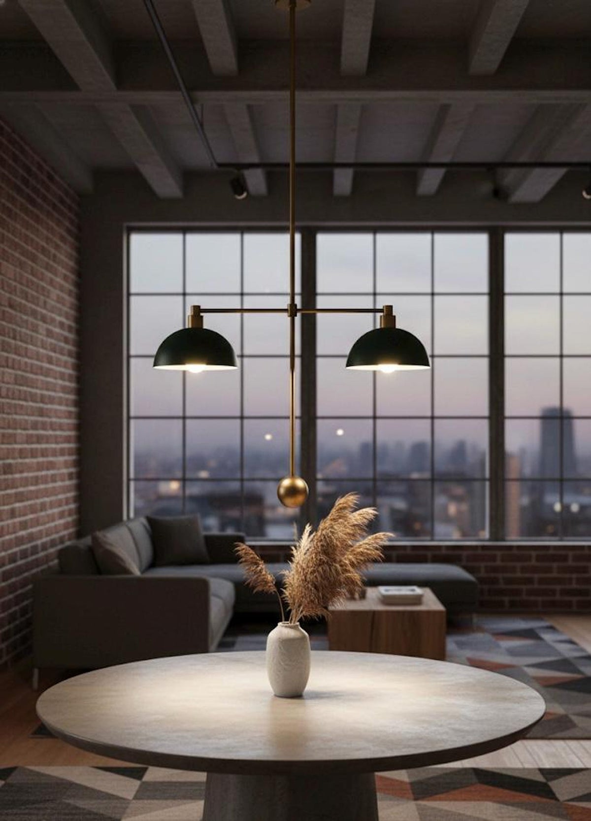 Brass double pendant with green dome shades hanging above a round table in an industrial loft living space at dusk.