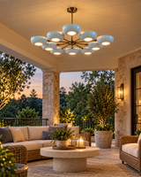 Lecce 10-light blue bowl chandelier shown illuminating a luxurious covered patio lounge with wicker seating, stone columns, and warm evening lighting.