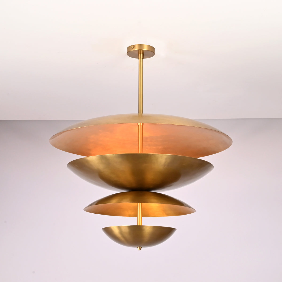 Illuminated front view of the Lior Modern Tiered Disc Chandelier showcasing soft glare-free light through layered metal discs