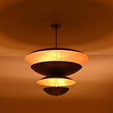 Night view of the Lior Modern Tiered Disc Chandelier producing soft diffused illumination through its floating tiered disc construction