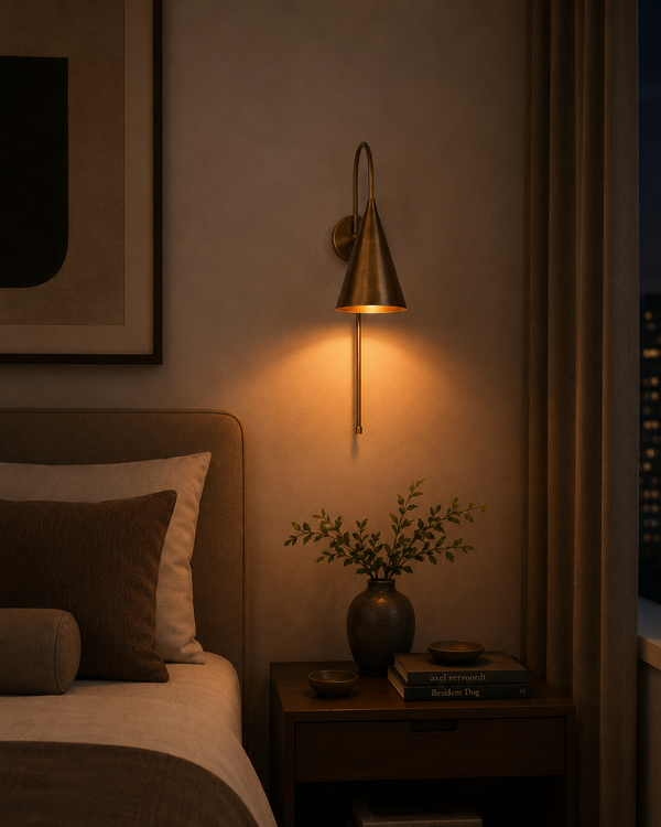 Liora Cone Loop Wall Sconce installed beside a bed in a warm modern bedroom interior.