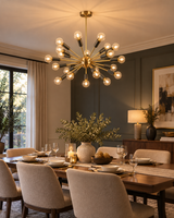 Lucca 24-light Mid-Century Modern Sputnik chandelier illuminating an elegant dining room with a wooden dining table, upholstered chairs, and warm ambient lighting.