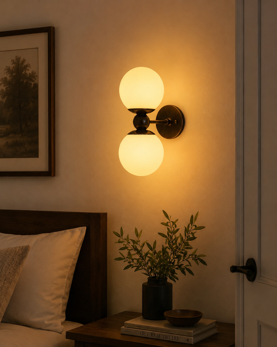 Luna double globe wall sconce illuminated beside a bed in a warm modern bedroom interior – Model 32837