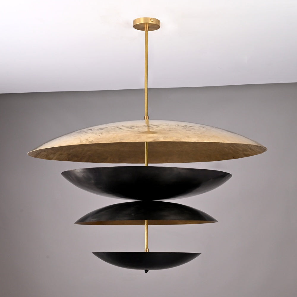 Elegant chandelier with a tiered design of alternating black and gold dome-shaped discs suspended on a brass rod, offering a striking sculptural look for modern interiors