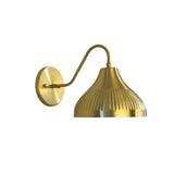 Front angled view of the Luna Fluted Dome Wall Sconce featuring a handcrafted fluted brass dome shade, curved wall arm, and round backplate in a modern Scandinavian design.