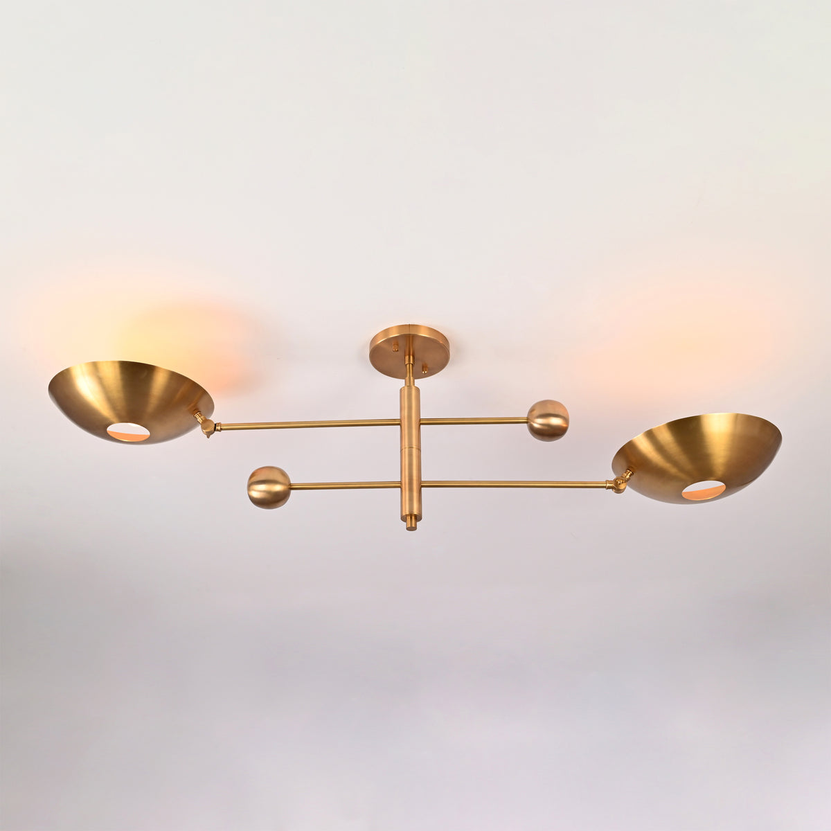 Perspective view of the Luna Modern Double Bowl Chandelier featuring asymmetrical bowl shades and Mid-Century Modern brass design