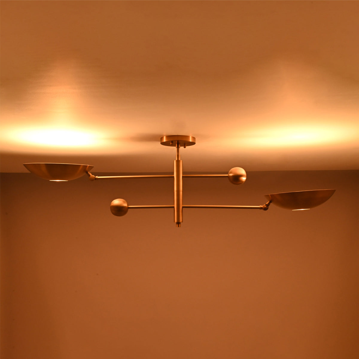 Illuminated view of the Luna Modern Double Bowl Chandelier casting warm indirect ceiling illumination through dual bowl shades