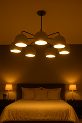 Matte black chandelier with seven dome-shaped lights casting a warm glow over a minimalist bedroom setting
