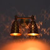 Luna double bell wall sconce glowing warmly with dotted perforation patterns across the surrounding wall.