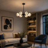 Marbella 6 light white dome chandelier illuminated in a cozy contemporary living room with warm evening ambient lighting.