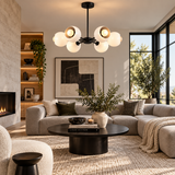 Marbella 6 light white dome chandelier with black radial frame displayed in a warm contemporary living room.