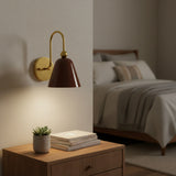 Angled view of Marlow bell shade wall sconce with warm brass curved arm and brown metal shade – Model 32809