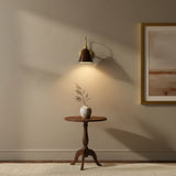 Marlow wall sconce featuring a dark bell-shaped metal shade, curved brass arm and round wall canopy – Model 32809