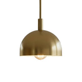 Angled view of Marlow modern brass dome pendant light with minimalist dome shade and exposed bulb.