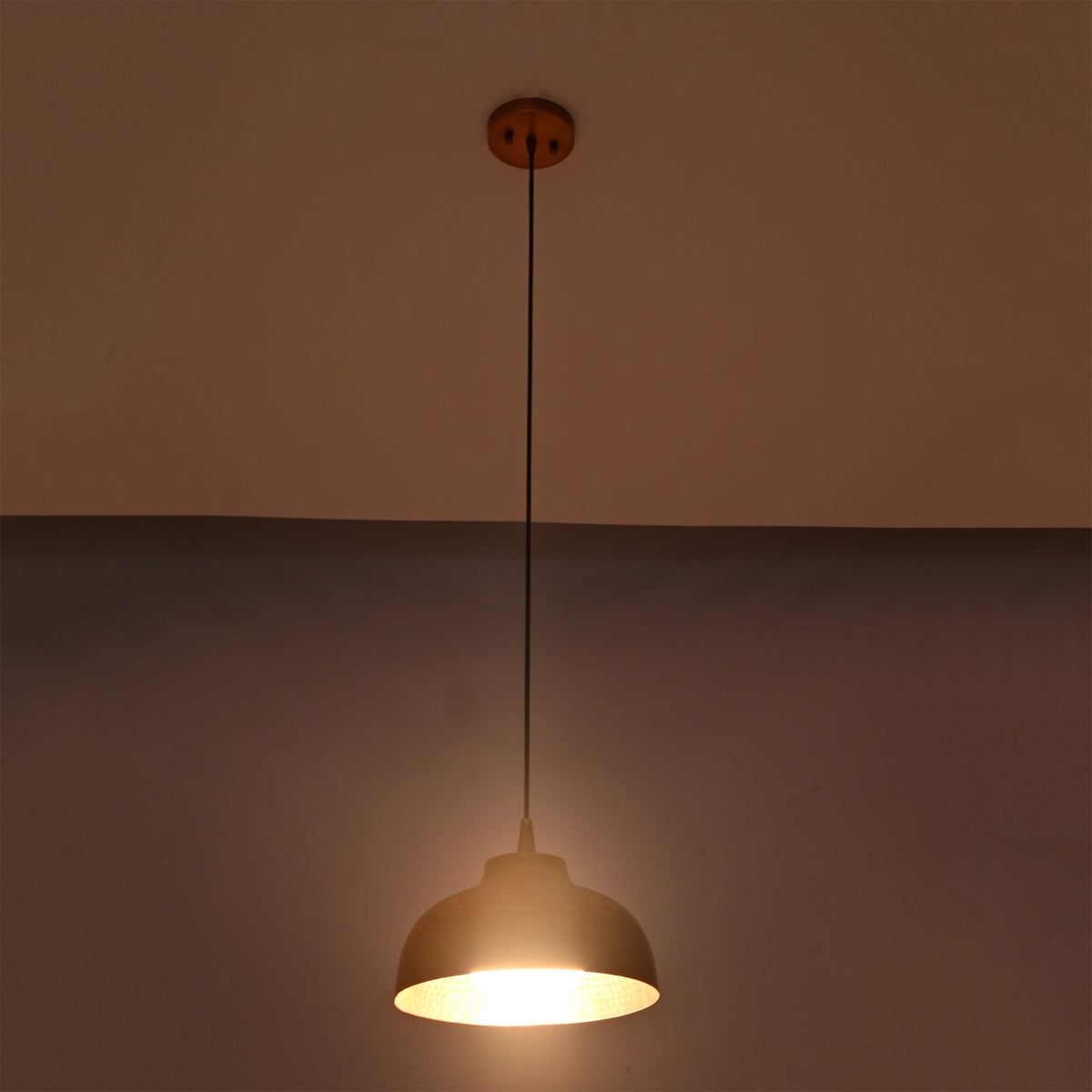 Bright illuminated view of the Marlow hammered copper dome pendant light featuring a textured copper dome with warm focused lighting.