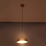 Bright illuminated view of the Marlow hammered copper dome pendant light featuring a textured copper dome with warm focused lighting.