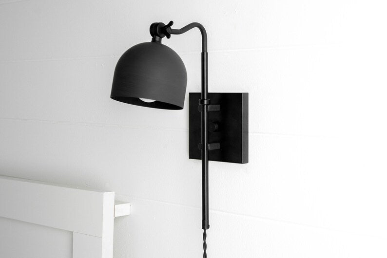 Adjustable solid brass wall sconce with matte black dome shade on square backplate, modern industrial wall light