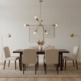 Melbourne 6 light Mid-Century Modern chandelier shown from the front with tapered cone holders, exposed globe bulbs, and sculptural brass-tone arms.