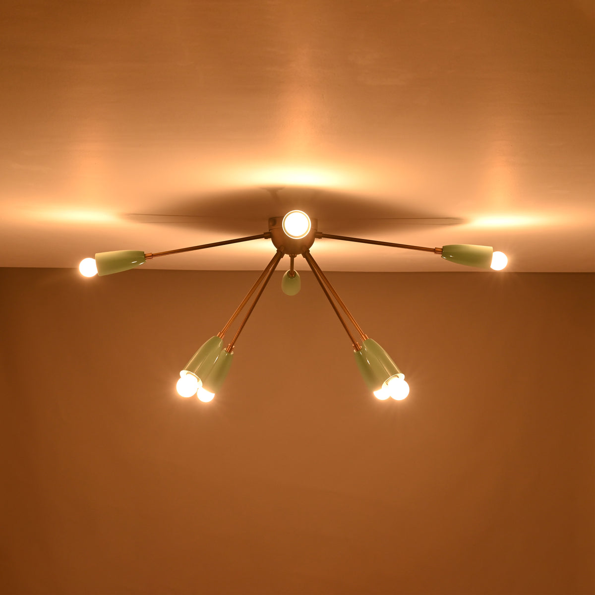 8-light brass and mint enamel flush mount chandelier glowing from ceiling