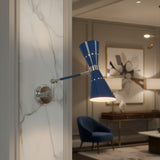 Angled view of Milan adjustable blue double cone wall sconce illuminated with warm light and polished metal details.