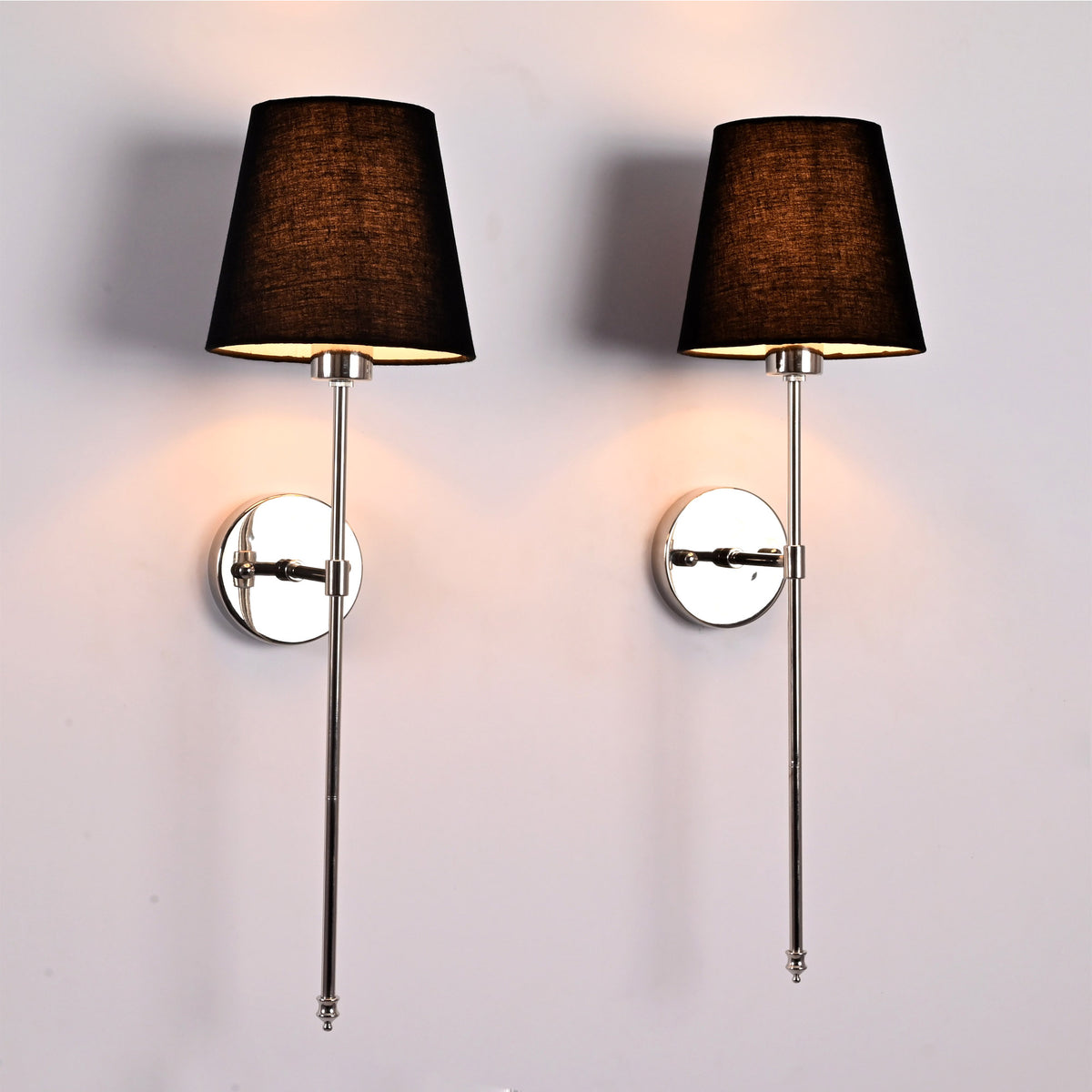 Front view of Milan black shade chrome rod wall sconces with slim vertical frames and round backplates.