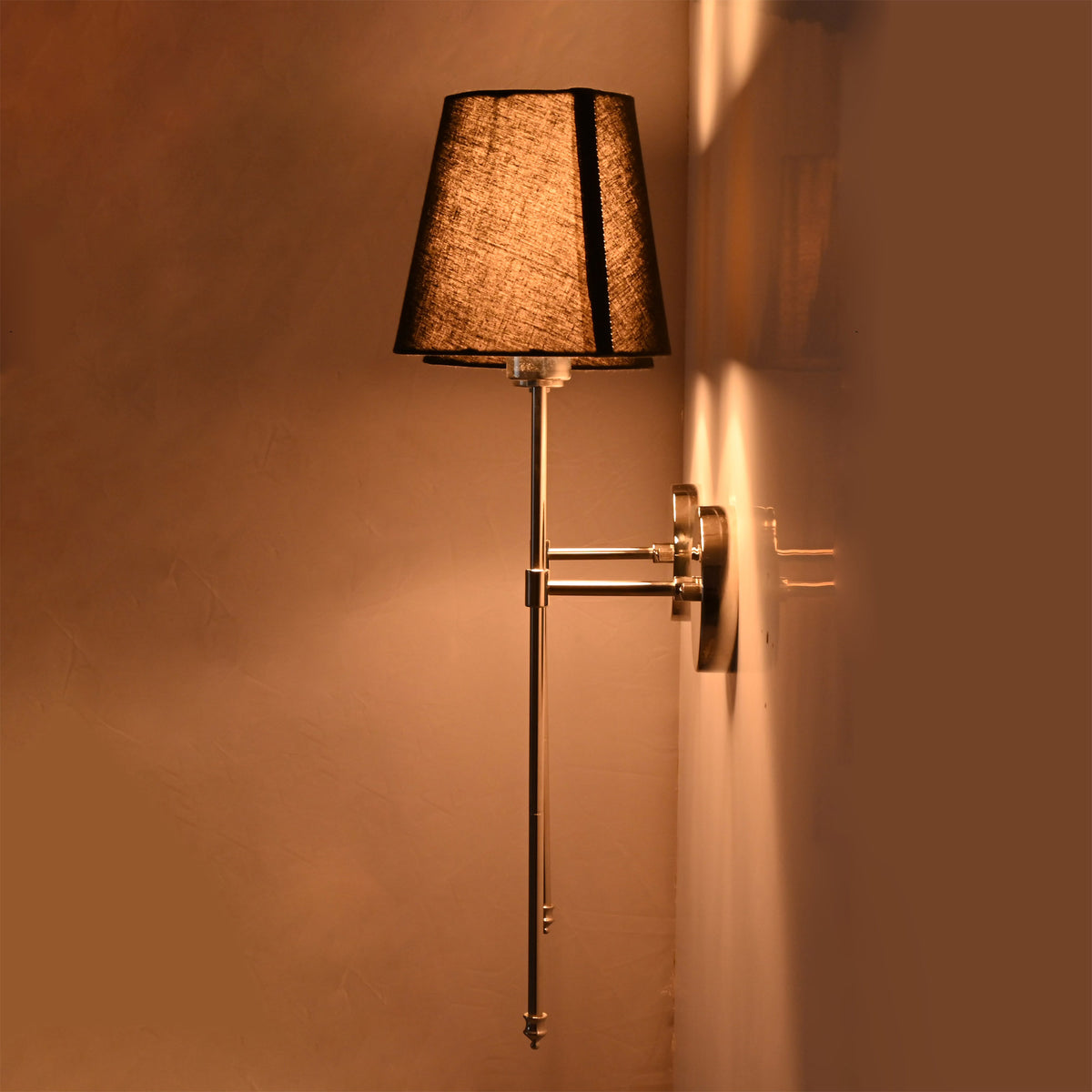 Side view of Milan black shade chrome wall sconce showing slim projection and warm shade lighting.