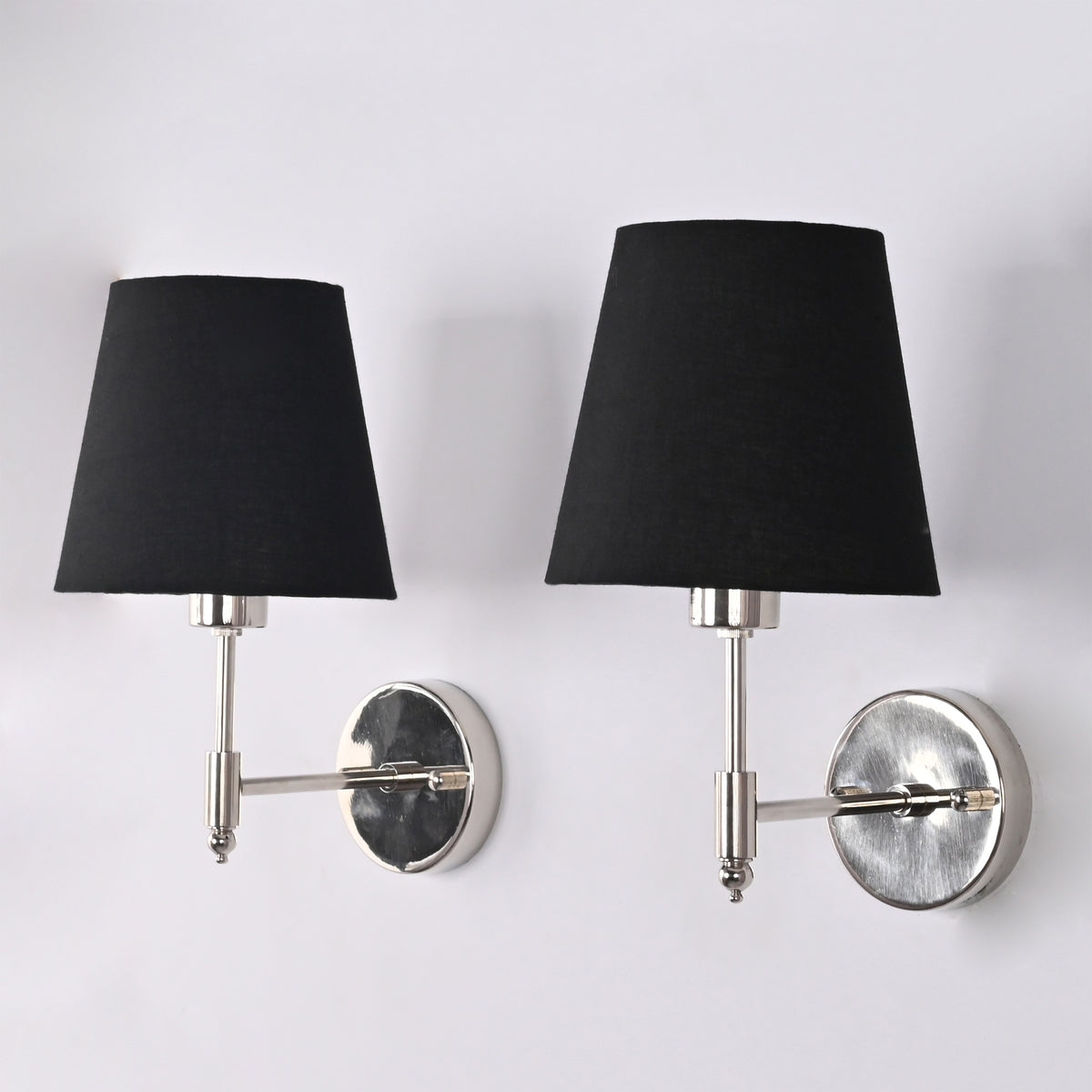Angled view of Milan polished chrome wall sconce featuring a black tapered fabric shade, solid brass construction, and contemporary wall-mounted design.