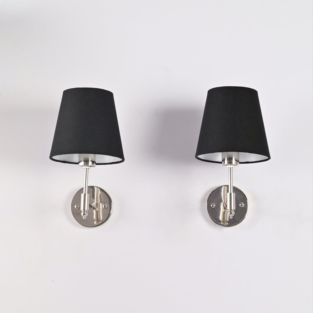 Front view of Milan black tapered fabric shade wall sconce with polished chrome finish and round wall backplate, modern 1-light hardwired wall fixture.