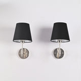 Front view of Milan black tapered fabric shade wall sconce with polished chrome finish and round wall backplate, modern 1-light hardwired wall fixture.