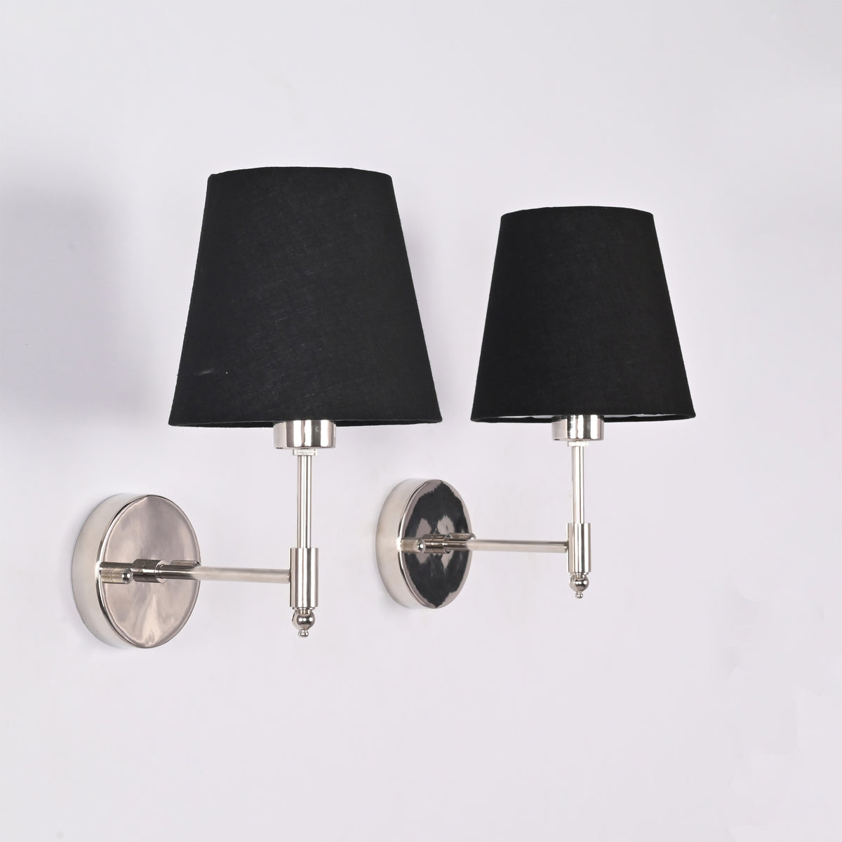 Side angle view of Milan polished chrome wall light with black fabric shade highlighting the slim wall arm and round chrome backplate.