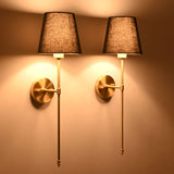 Pair of illuminated black shade wall sconces creating warm ambient glow with refined classic styling.