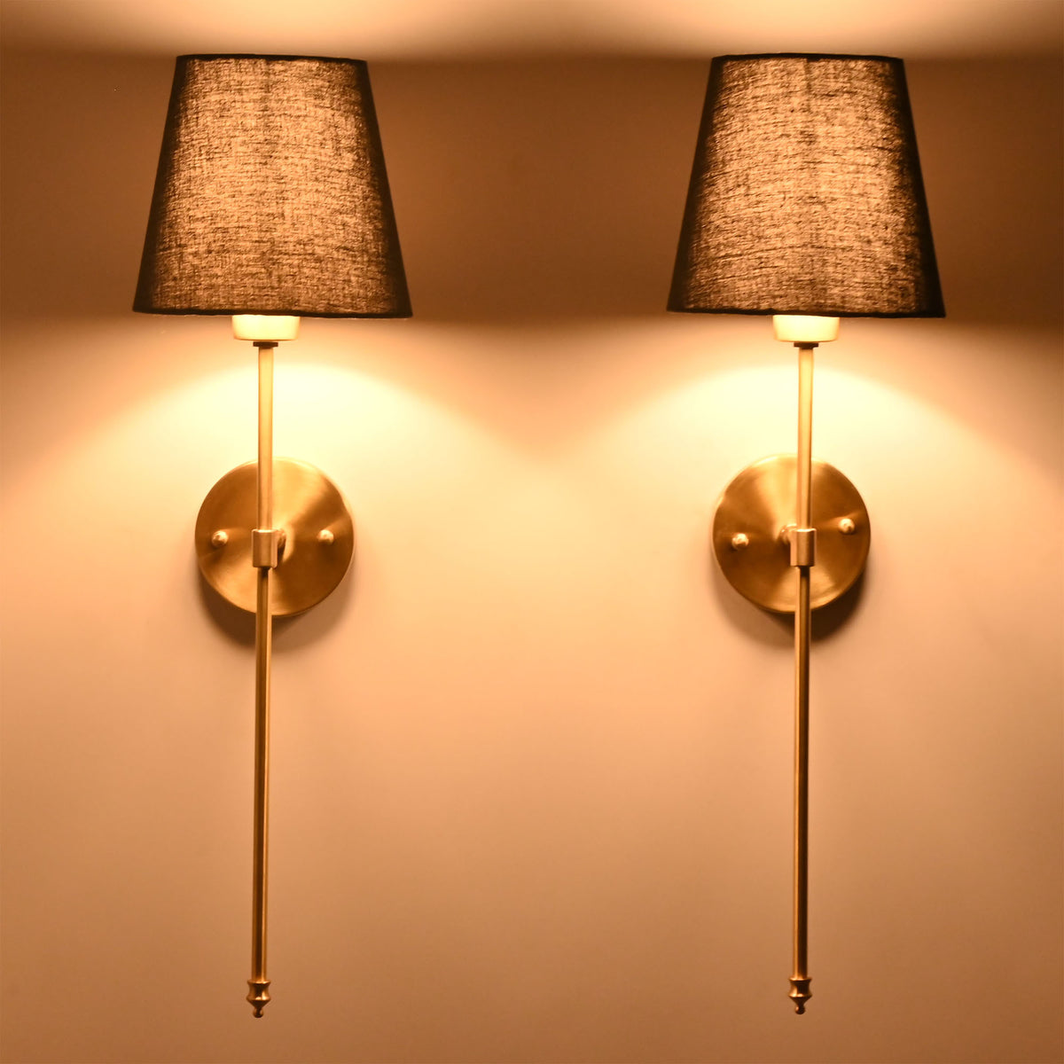 Side angle of black shade rod wall sconce showing warm light effect and elegant wall projection.