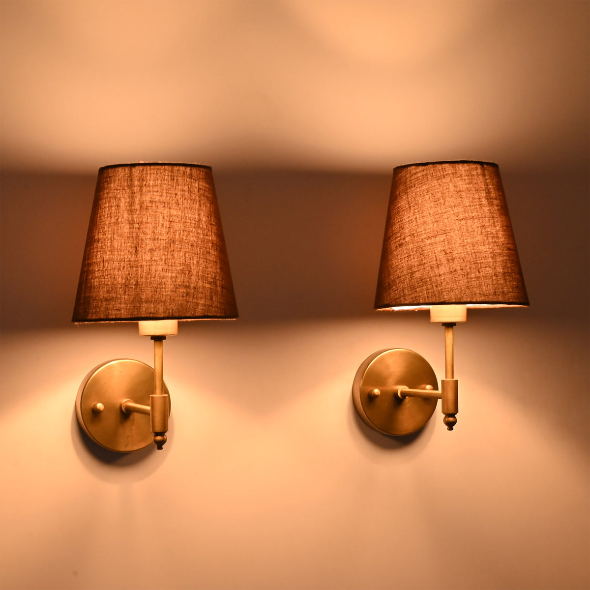 Matching pair of Milan Brown Shade Antique Brass Short Wall Sconces installed on a wall with warm decorative lighting.