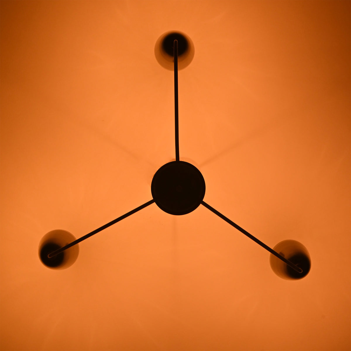 Bottom view of Milan Cone Arm Chandelier showing three arm layout and warm ceiling light effect.