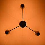 Bottom view of Milan Cone Arm Chandelier showing three arm layout and warm ceiling light effect.